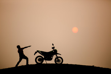 Fototapeta na wymiar motorbike and biker with sunset background