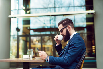 Businessman checking email and drinking coffee.
