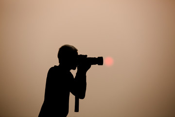 silhouette photographer at sunrise