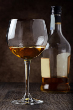 bicchiere e bottiglia di liquore ambrato