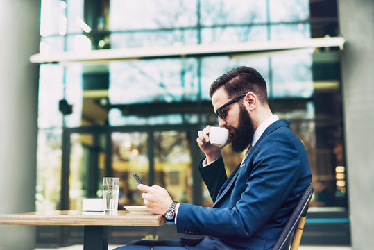 Businessman checking email and drinking coffee.