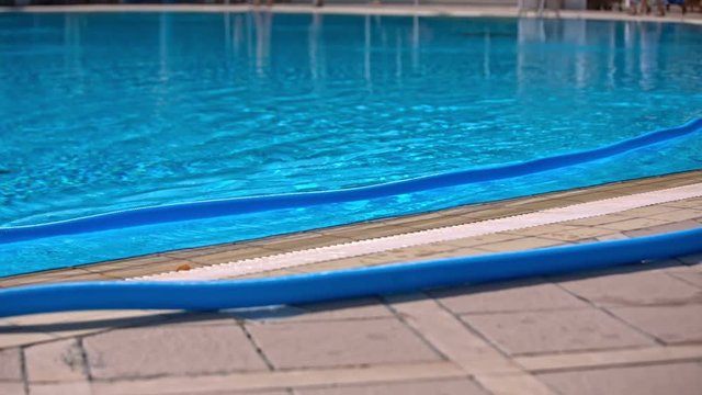 Person stretch plastic hose at swimming pool