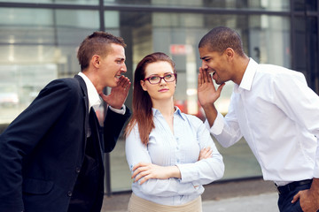 Two businessmen screaming at business woman.