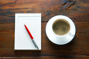 Coffee and red pen on notes and calculator with nature wood background,copy space