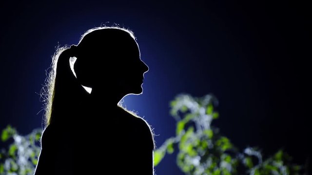 Woman with ponytail hair looking in distance silhouette
