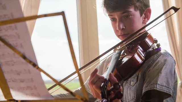 Front close up boy play violin in slow motion