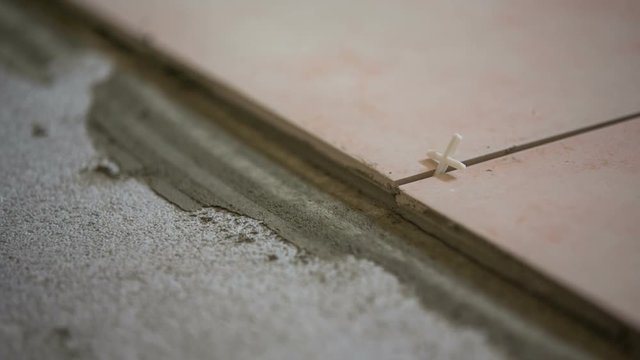 Tiles on concrete floor glued together close up