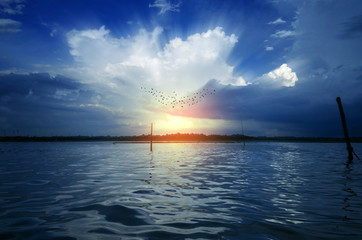 Fototapeta na wymiar Morning birds flying on dramatic sky at sunrise sunset