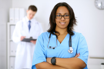 Female african american medical doctor with colleagues in background
