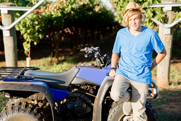 Naklejka premium Boy standing next to truck in vineyard