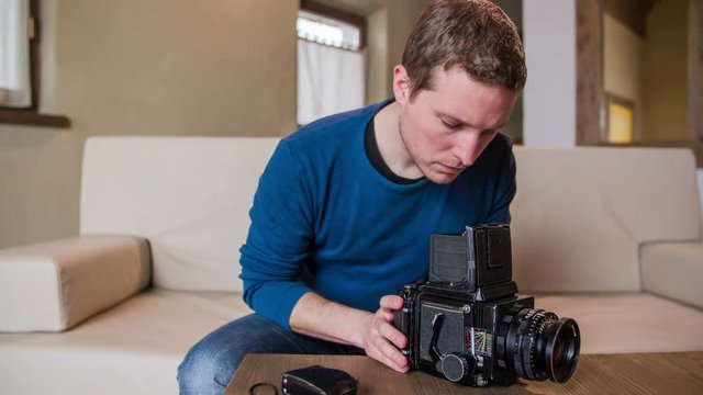Man holding retro camera on table