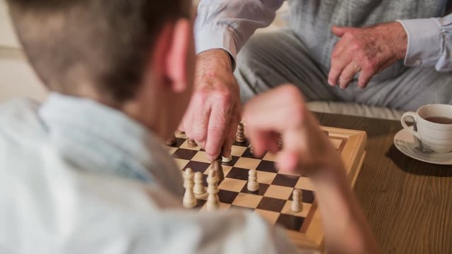 Boy over shoulder view playing game of chess