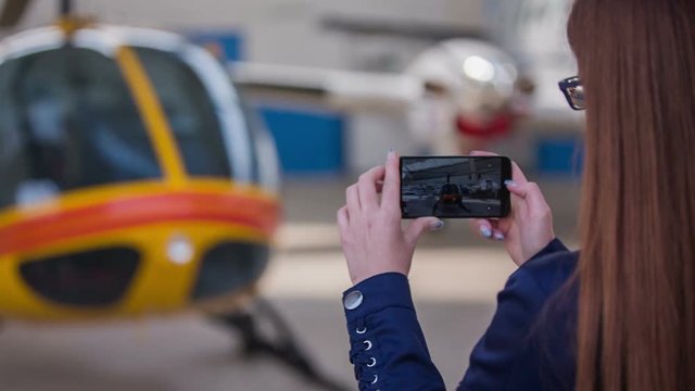 Person photographing a helicopter in hangar