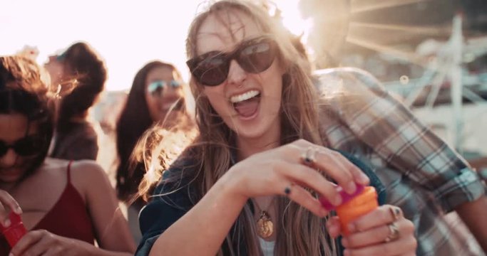 Hipster friend partying with bubbles at the harbor on sunset