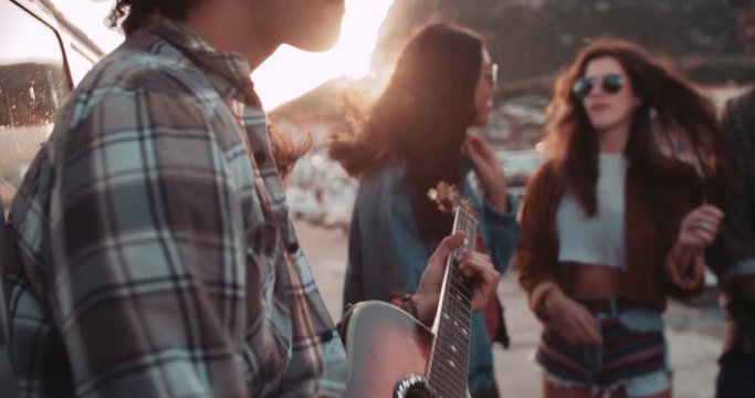 Hipster teen friends having fun with guitar on road trip