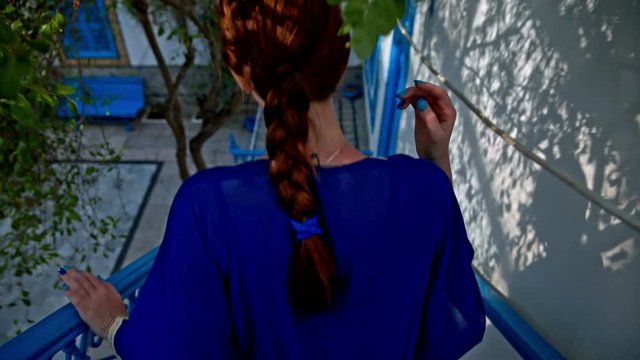 Woman walk down stairs in Sidi Bou Said house