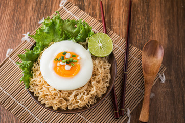 Instant noodles with egg in bowl and vegetable