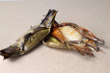 Sticky Rice with Coconut Milk and Taro in banana leaf on wood table (Thai dessert)