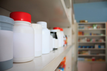 medicine bottles arranged on shelf at drugstore