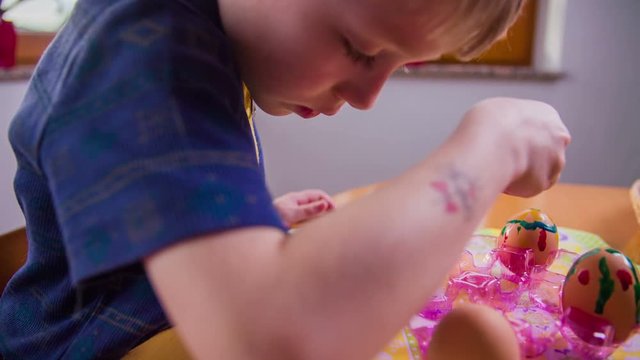 Carefully painting on egg in slow motion