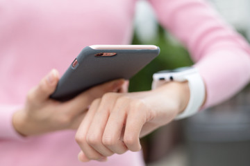 Woman using mobile phone and watch