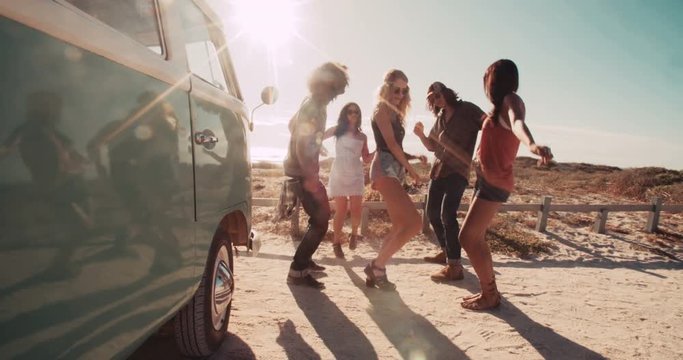 Multi-Ethnic Hipster Friends Laughing and partying While dancing next to van