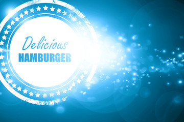 Blue stamp on a glittering background: Delicious hamburger sign