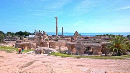 Carthage spa ruins with two tourist exploring - Powered by Adobe
