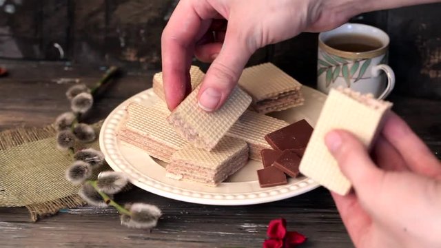 chocolate waffles on a plate on a wooden table hand break, willow, still life,