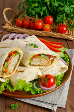 Fresh tortilla wraps with kebab and fresh vegetables on plate