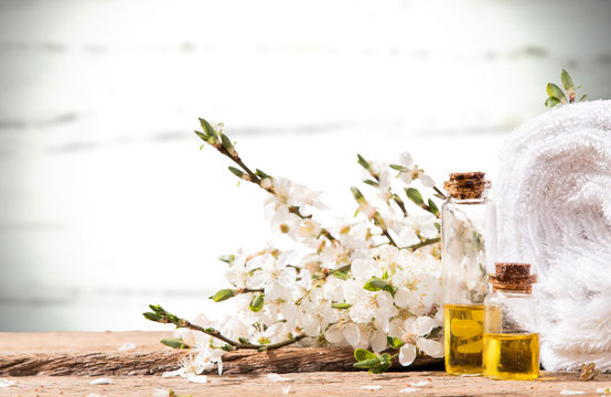 spa massage setting, spring flower. product, oil on wooden background