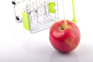 Shopping Cart with Red Organic Apple on white background