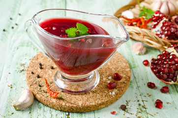 Fresh pomegranate sauce for meat on a wooden table