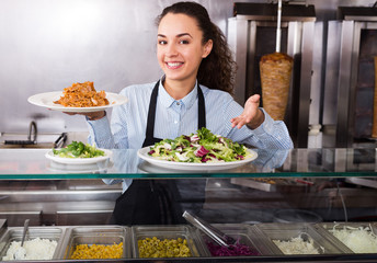 Smiling brunette girl with kebab and vegetables