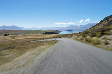 empty road near lake in summer day in new zealand