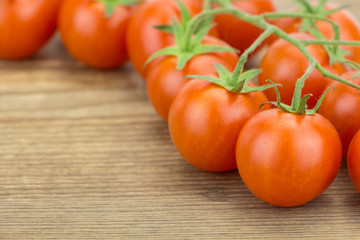 Heap of cherry tomatoes, on wooden surface.