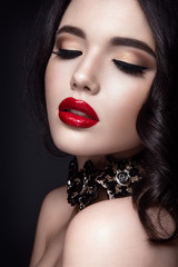 Beautiful woman portrait. Young lady posing close up on black background. Glamour make up, red lipstick. Gorgeous jewelry on neck. - 107413183