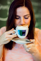 Young brunette woman sitting at a coffeeshop and relaxing