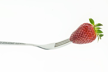 Fresh juicy strawberry on fork, on white background.