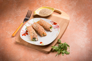 salmon rolled up with sesame seeds ricotta and arugula