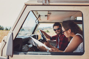 Couple looking at the map in their car - Powered by Adobe