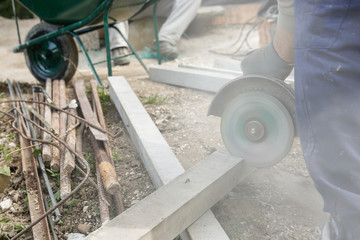 Construction worker cutting a reinforced concrete pillar
