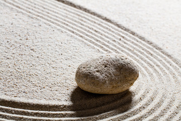 Fototapeta na wymiar zen sand still-life - one pebble for concept of suppleness or flexibility with care and smoothness