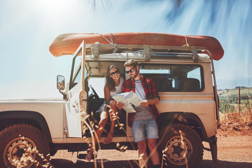 Young couple using map on a roadtrip