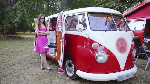 Red retro camper van with woman posing