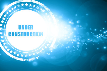 Blue stamp on a glittering background: Under construction sign