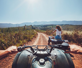 Young people on quad bikes on mountain trail
