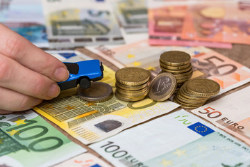 Toy car with helping hand on coin and euro banknote