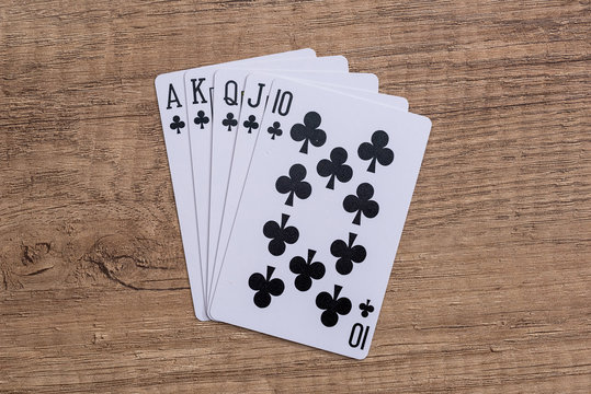 Set of Clubs suit playing cards on wooden desk