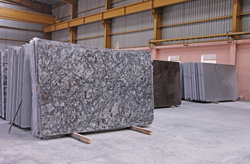 Various shades of Indian polished natural granite floor slabs kept in stacks in storehouse - obrazy, fototapety, plakaty